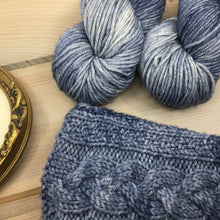 Load image into Gallery viewer, Dusty blue semi-solid, DK-weight yarn with the corner of a knitted sweater